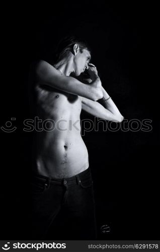 young slender naked man on a black background