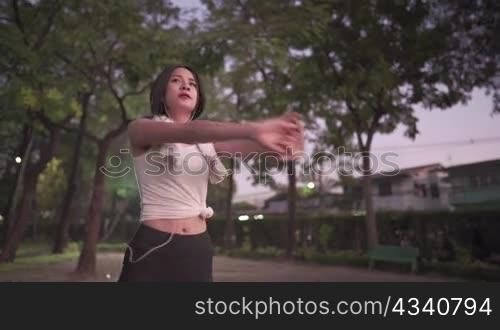Young slim attractive black hair asian woman stretching body before exercising in evening at park, athletic female warming up body after office hours, activity after daily working, healthy lifestyle