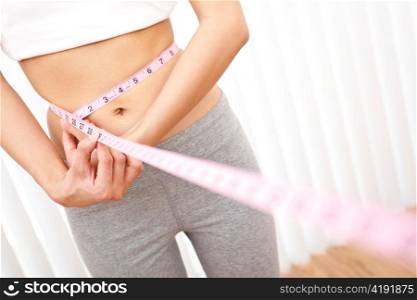 Young Slim Woman Measuring Waist With Tape Measure