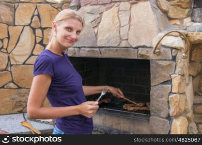 Young slim woman prepares the meat in barbecue grill