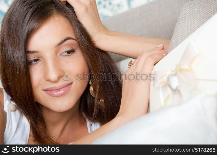Young smiley elegant Woman lying on her sofa with her elegant letter