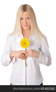 Young smiling blonde in a white shirt plays with a yellow flower in the hands