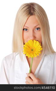 Young smiling blonde in a white shirt plays with a yellow flower in the hands