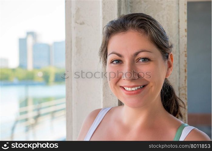 Young smiling brunette in the city, close-up portrait