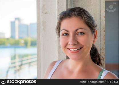 Young smiling brunette in the city, close-up portrait