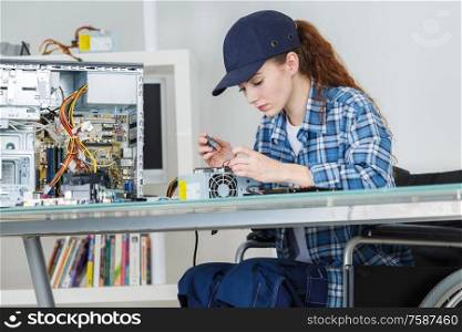 young smiling brunette woman technician repairs a computer