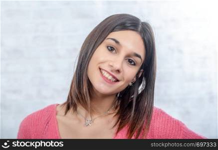 young smiling brunette woman with a pink sweater