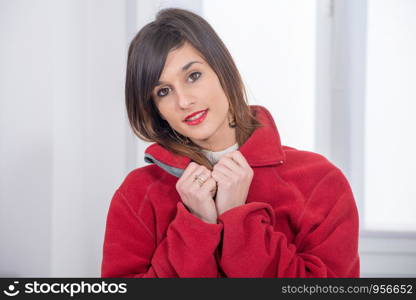 young smiling brunette woman with a red jacket