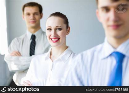 Young smiling businessman. Smiling successful businessman with colleagues at background