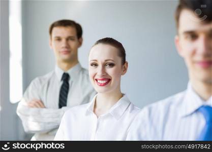 Young smiling businessman. Smiling successful businessman with colleagues at background