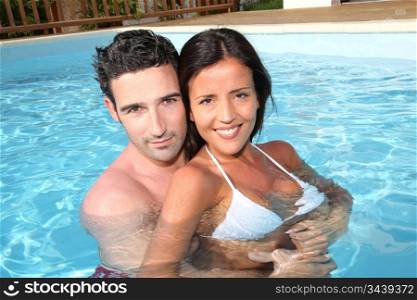 Young smiling couple bathing in private pool
