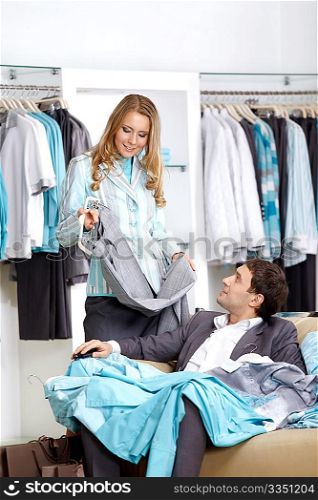 Young smiling couple in shop choose clothes
