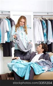 Young smiling couple in shop choose clothes