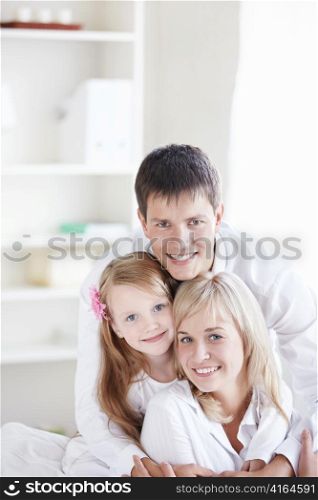 Young smiling couple with a child at home