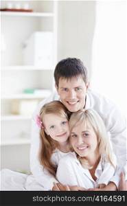 Young smiling couple with a child at home