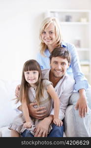 Young smiling family with a child at home