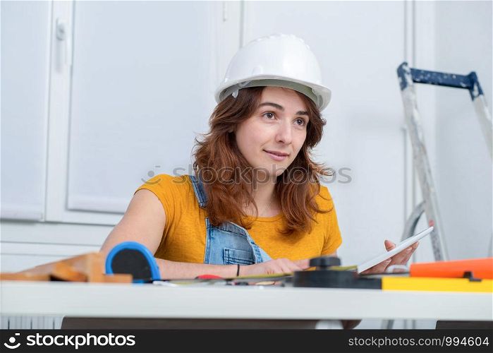 young smiling female architect with helmet in the office