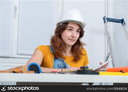 young smiling female architect with helmet in the office