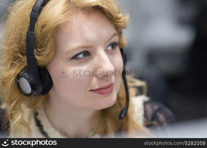 young smiling female call centre operator doing her job with a headset