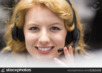 young smiling female call centre operator doing her job with a headset