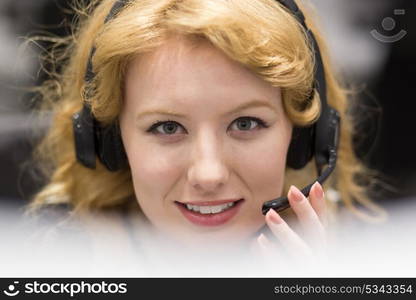 young smiling female call centre operator doing her job with a headset