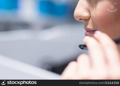 young smiling female call centre operator doing her job with a headset