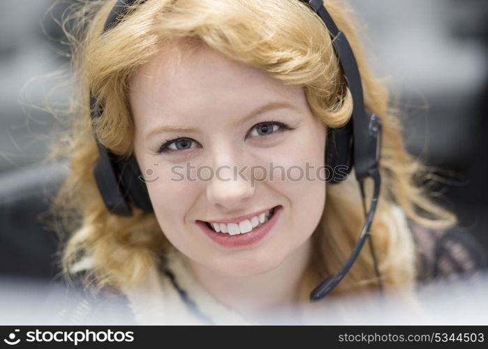 young smiling female call centre operator doing her job with a headset