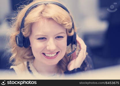 young smiling female call centre operator doing her job with a headset