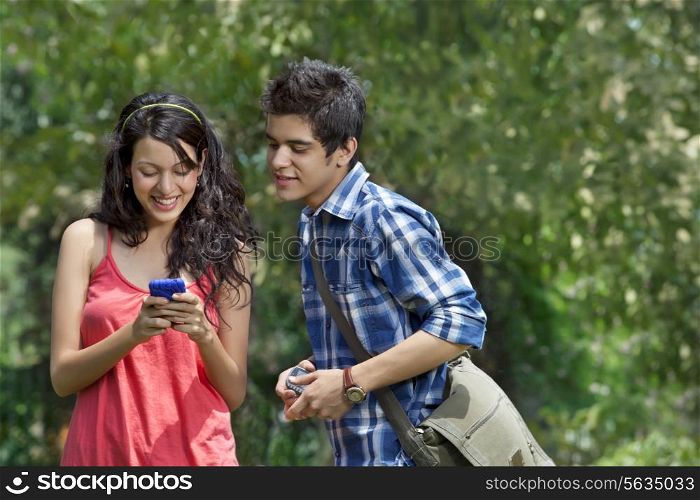 Young smiling friends looking at cell phone