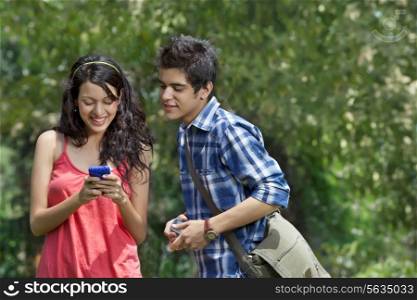Young smiling friends looking at cell phone