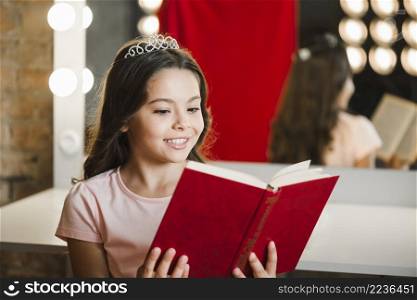 young smiling girl reading book