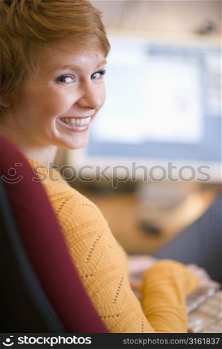 Young smiling girl sitting looking over shoulder
