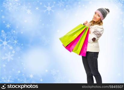 Young smiling girl with bags on winter background