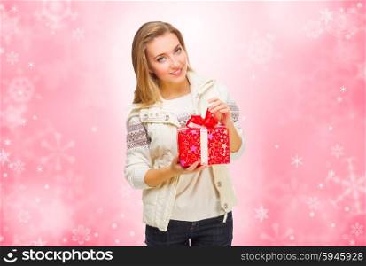 Young smiling girl with gift box on red winter background