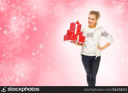 Young smiling girl with gift boxes on winter background
