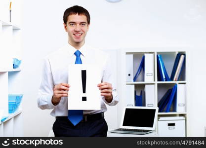 Young smiling happy businessman at work in office