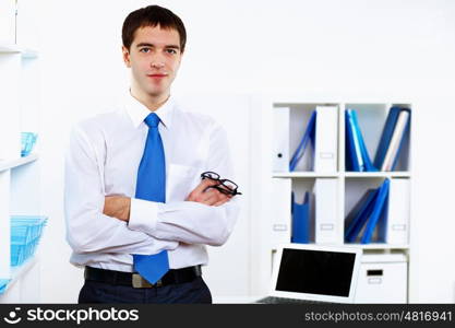 Young smiling happy businessman at work in office