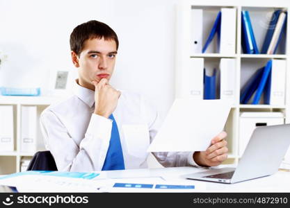 Young smiling happy businessman at work in office