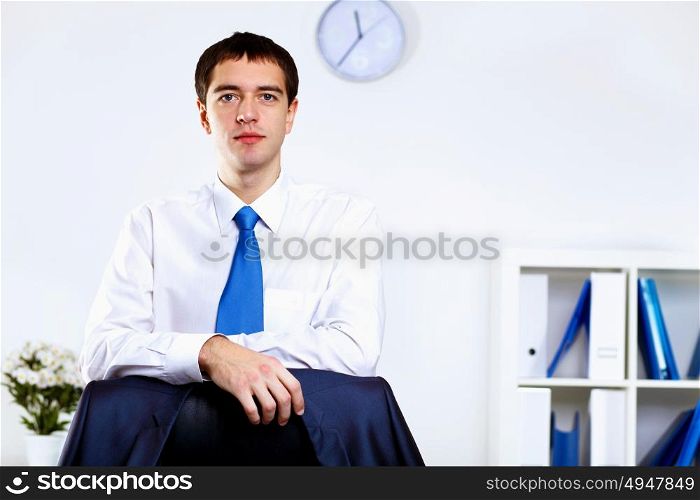 Young smiling happy businessman at work in office