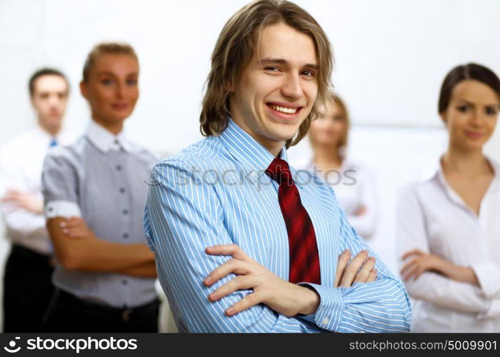 Young smiling happy businessman at work in office