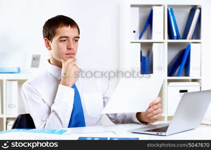 Young smiling happy businessman at work in office