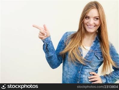 Young smiling lady gesturing. Cheering young girl pointing finger. Communication lifestyle leisure fashion concept. . Young smiling lady gesturing.