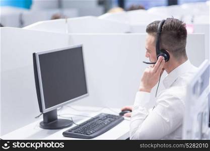 young smiling male call centre operator doing his job with a headset