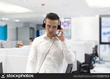 young smiling male call centre operator doing his job with a headset