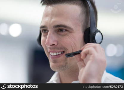 young smiling male call centre operator doing his job with a headset