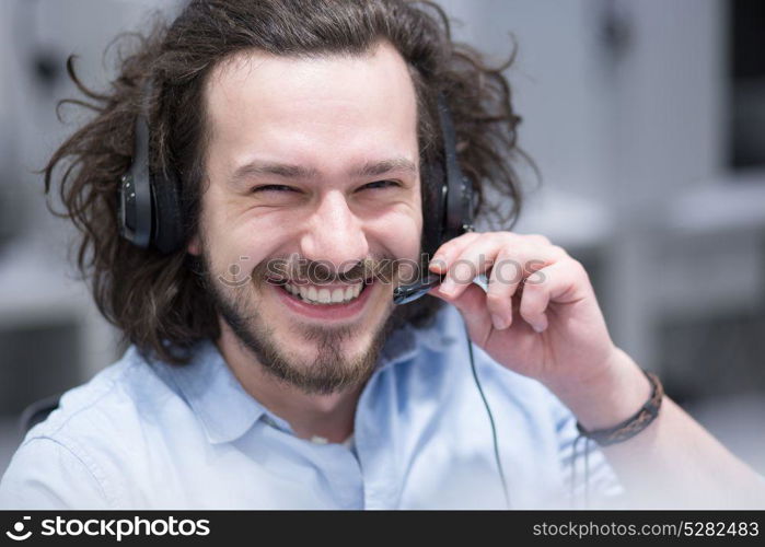 young smiling male call centre operator doing his job with a headset