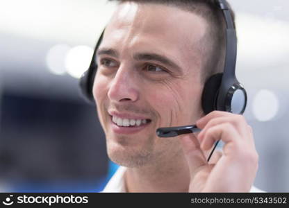 young smiling male call centre operator doing his job with a headset