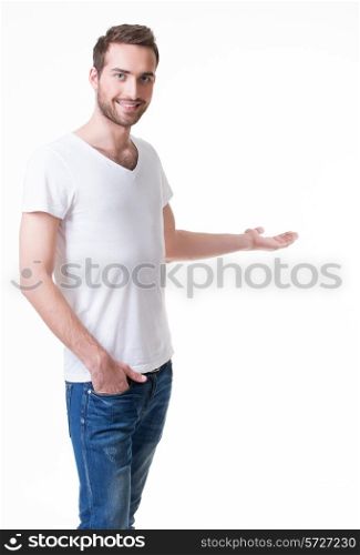 Young smiling man shows something on arm - isolated on white.