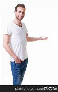 Young smiling man shows something on arm - isolated on white.