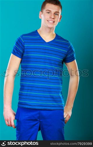 Young smiling man teen boy portrait studio shot on blue background